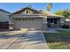 Charming single-Gathering home featuring a two-car garage and well-maintained front yard in a desert landscape at 7027 W Midway Ave, Glendale, AZ 85303
