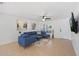 Bright living room with a cozy blue sectional, modern artwork, and large windows offering ample natural light at 7027 W Midway Ave, Glendale, AZ 85303