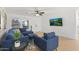 Comfortable living room featuring a plush blue sofa set, tiled floors, and a mounted TV, ideal for relaxation at 7027 W Midway Ave, Glendale, AZ 85303