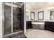 A bathroom featuring dark wood cabinets, a tiled soaking tub, and a glass-enclosed shower at 820 E Constance Way, Phoenix, AZ 85042