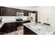 Modern kitchen boasts stainless steel appliances, granite countertops, and dark wood cabinetry at 820 E Constance Way, Phoenix, AZ 85042