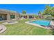 Aerial view of the property showcasing the pool, spa, manicured lawn, and desert landscape at 8306 E Buckskin Trl, Scottsdale, AZ 85255