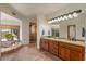 Bathroom featuring a soaking tub with large windows, a double sink vanity, and travertine tile flooring at 8306 E Buckskin Trl, Scottsdale, AZ 85255