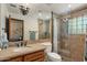Well-lit bathroom with stone countertops, a large mirror, and glass-enclosed shower at 8306 E Buckskin Trl, Scottsdale, AZ 85255