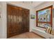 Grand foyer with a large wooden front door, window seat and views of a landscaped courtyard at 8306 E Buckskin Trl, Scottsdale, AZ 85255