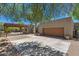 Spacious garage with wood door, complemented by a shaded pergola and desert landscaping at 8306 E Buckskin Trl, Scottsdale, AZ 85255