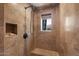 Shower area with tan tiled walls, shower head, and corner seat at 8306 E Buckskin Trl, Scottsdale, AZ 85255