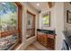 Wet bar area featuring granite counters, wooden cabinets and convenient wine rack, flooded with natural light at 8306 E Buckskin Trl, Scottsdale, AZ 85255