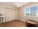 This bedroom features wood floors, a ceiling fan, closet, and a bright window at 9011 N 52Nd Ave, Glendale, AZ 85302