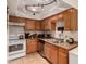 Bright kitchen featuring wooden cabinets, tile flooring, and modern stainless steel appliances at 9011 N 52Nd Ave, Glendale, AZ 85302