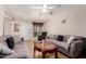The living room features neutral toned sofas, tile floor, overhead fan and large front window at 9011 N 52Nd Ave, Glendale, AZ 85302