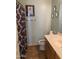 Bathroom featuring tile floor, a wooden vanity, and a shower with patterned curtain at 9018 W Superior Ave, Tolleson, AZ 85353