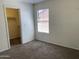 Cozy bedroom featuring neutral carpet, a window with blinds, and a spacious closet at 9018 W Superior Ave, Tolleson, AZ 85353