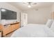 Cozy bedroom featuring a ceiling fan, large TV, and light wood entertainment center at 930 S Dobson Rd # 3, Mesa, AZ 85202