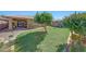 Manicured backyard featuring lush green lawn, flowering bushes, and patio area at 9926 W Gross Ave, Tolleson, AZ 85353