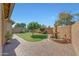 Backyard oasis featuring a water fountain, lush lawn, and a brick-paved area at 9926 W Gross Ave, Tolleson, AZ 85353