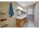Well-lit bathroom featuring double sinks, a large mirror, and a tiled floor at 9926 W Gross Ave, Tolleson, AZ 85353