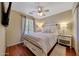 Cozy bedroom featuring hardwood floors, ceiling fan, and a comfortable queen-sized bed at 9926 W Gross Ave, Tolleson, AZ 85353