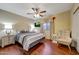 Relaxing bedroom with a wooden floor, accent chair, ceiling fan, and bedside lamps at 9926 W Gross Ave, Tolleson, AZ 85353
