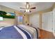 Comfortable bedroom featuring a ceiling fan, sliding closet doors, and warm lighting at 9926 W Gross Ave, Tolleson, AZ 85353