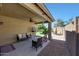 Relaxing covered patio with outdoor seating, fan, and a view of the landscaped backyard at 9926 W Gross Ave, Tolleson, AZ 85353