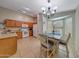 Well-lit dining area, with tile flooring and a chandelier, adjacent to the kitchen, perfect for Gathering meals at 9926 W Gross Ave, Tolleson, AZ 85353
