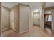 Neutral hallway with ceramic tile flooring leading to a bright entryway and bedrooms at 9926 W Gross Ave, Tolleson, AZ 85353