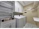 Functional laundry room featuring modern appliances, storage cabinets, and a utility sink at 9926 W Gross Ave, Tolleson, AZ 85353