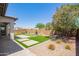 Serene backyard featuring artificial turf, a blooming tree, and elegant hardscape at 10240 E Supernova Dr, Mesa, AZ 85212