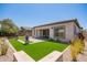 Inviting backyard with lush artificial turf, elegant pavers, and serene landscaping at 10240 E Supernova Dr, Mesa, AZ 85212