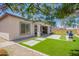 Beautifully landscaped backyard with artificial turf, stone pavers, and a blooming tree at 10240 E Supernova Dr, Mesa, AZ 85212