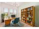 Bright home office with sleek desk, a bookshelf, and natural light at 10240 E Supernova Dr, Mesa, AZ 85212