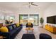 Open-concept living room with large windows, modern furniture, and an adjacent dining area at 10240 E Supernova Dr, Mesa, AZ 85212