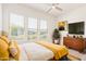 Bright main bedroom featuring large windows, a ceiling fan, and stylish modern furniture at 10240 E Supernova Dr, Mesa, AZ 85212