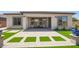 Inviting covered patio featuring pavers with artificial grass and comfortable seating area at 10240 E Supernova Dr, Mesa, AZ 85212