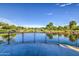 Beautiful pond view with a lakeside outlook, greenery, blue sky, and surrounding lush landscaping at 10240 E Supernova Dr, Mesa, AZ 85212