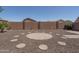 The backyard features a stone-lined circle surrounded by a rock garden and surrounded by a brick wall at 10618 W Pima St, Tolleson, AZ 85353