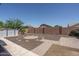 The backyard features a stone-lined circle surrounded by a rock garden and surrounded by a brick wall at 10618 W Pima St, Tolleson, AZ 85353