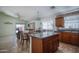 Well-lit kitchen with center island, dining table, and tile flooring at 10618 W Pima St, Tolleson, AZ 85353