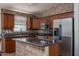 Well-lit kitchen features tiled backsplash, stainless steel appliances, and functional island at 10618 W Pima St, Tolleson, AZ 85353