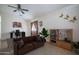 Staged living room featuring a brown sofa, desk, and various plants at 10618 W Pima St, Tolleson, AZ 85353