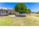 Large backyard showcasing mature shade trees, a green lawn, and a screened in porch at 10651 W Saratoga Cir, Sun City, AZ 85351