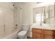 Bathroom with a single sink vanity, toilet, and tiled shower-tub combo at 16264 W Pioneer St, Goodyear, AZ 85338