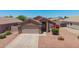 A house with desert landscaping in the front yard featuring shrubbery and colorful blooms at 16264 W Pioneer St, Goodyear, AZ 85338