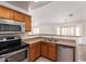 Efficient kitchen with stainless steel appliances, wood cabinets, and dual basin sink at 16264 W Pioneer St, Goodyear, AZ 85338