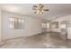 Bright living room with natural light, a ceiling fan, and open access to the kitchen area at 16264 W Pioneer St, Goodyear, AZ 85338