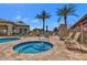 Community hot tub and swimming pool with patio seating and swaying palm trees at 17449 N Fairway Dr, Surprise, AZ 85374