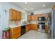 Well-lit kitchen boasts wood cabinets, stainless-steel appliances, and ample counter space for meal prep at 17449 N Fairway Dr, Surprise, AZ 85374