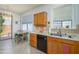 Sunny kitchen area featuring wood cabinets, black dishwasher, and an adjacent breakfast nook with natural light at 17449 N Fairway Dr, Surprise, AZ 85374