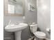 Cozy powder room with pedestal sink, toilet, and decorative mirror enhances functionality at 1920 E Bell Rd # 1165, Phoenix, AZ 85022